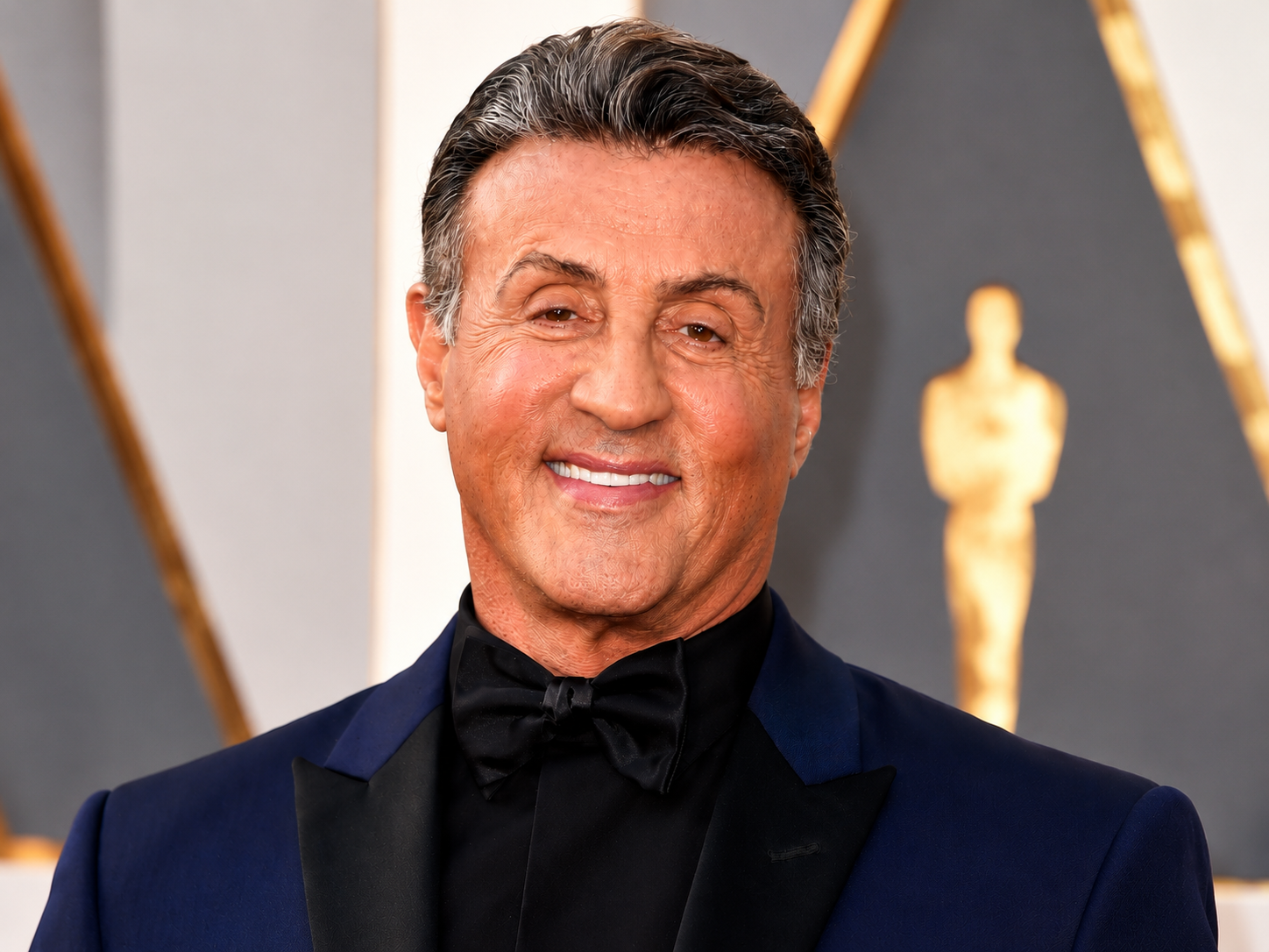 Sylvester Stallone net worth 2026 – smiling in a dark tuxedo at a formal awards event