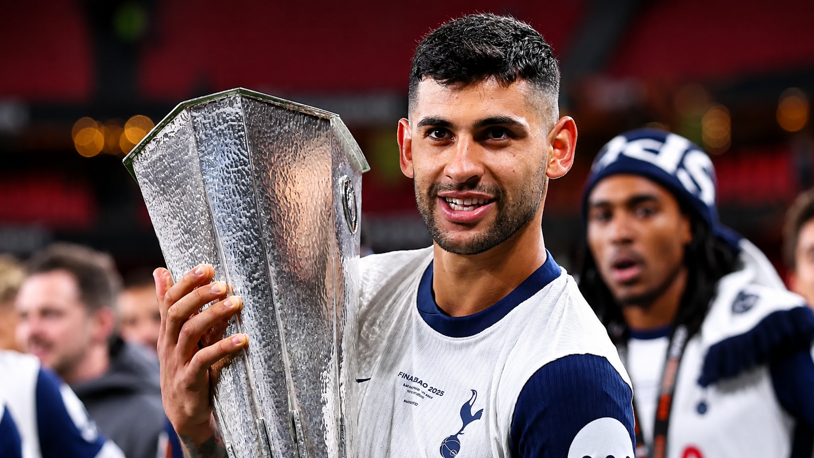 Cristian Romero holding a trophy during a soccer celebration