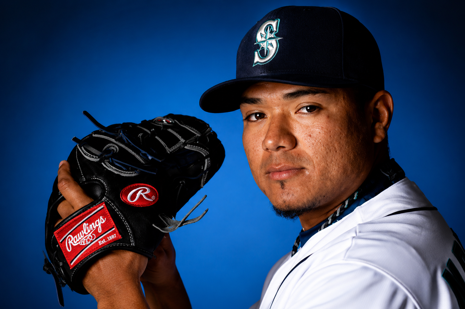 Erasmo Ramirez posing with a baseball glove in a Seattle Mariners uniform