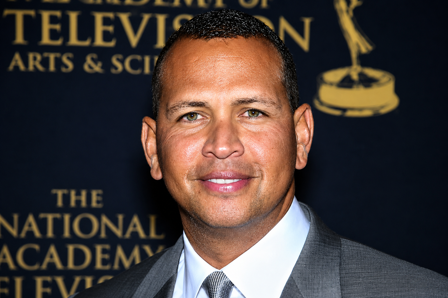 Alex Rodriguez posing in a gray suit at an awards event