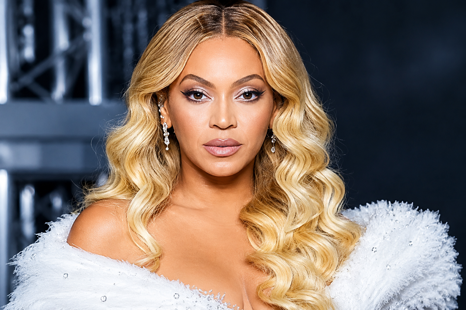 Beyoncé Knowles posing in a glamorous white gown with blonde waves