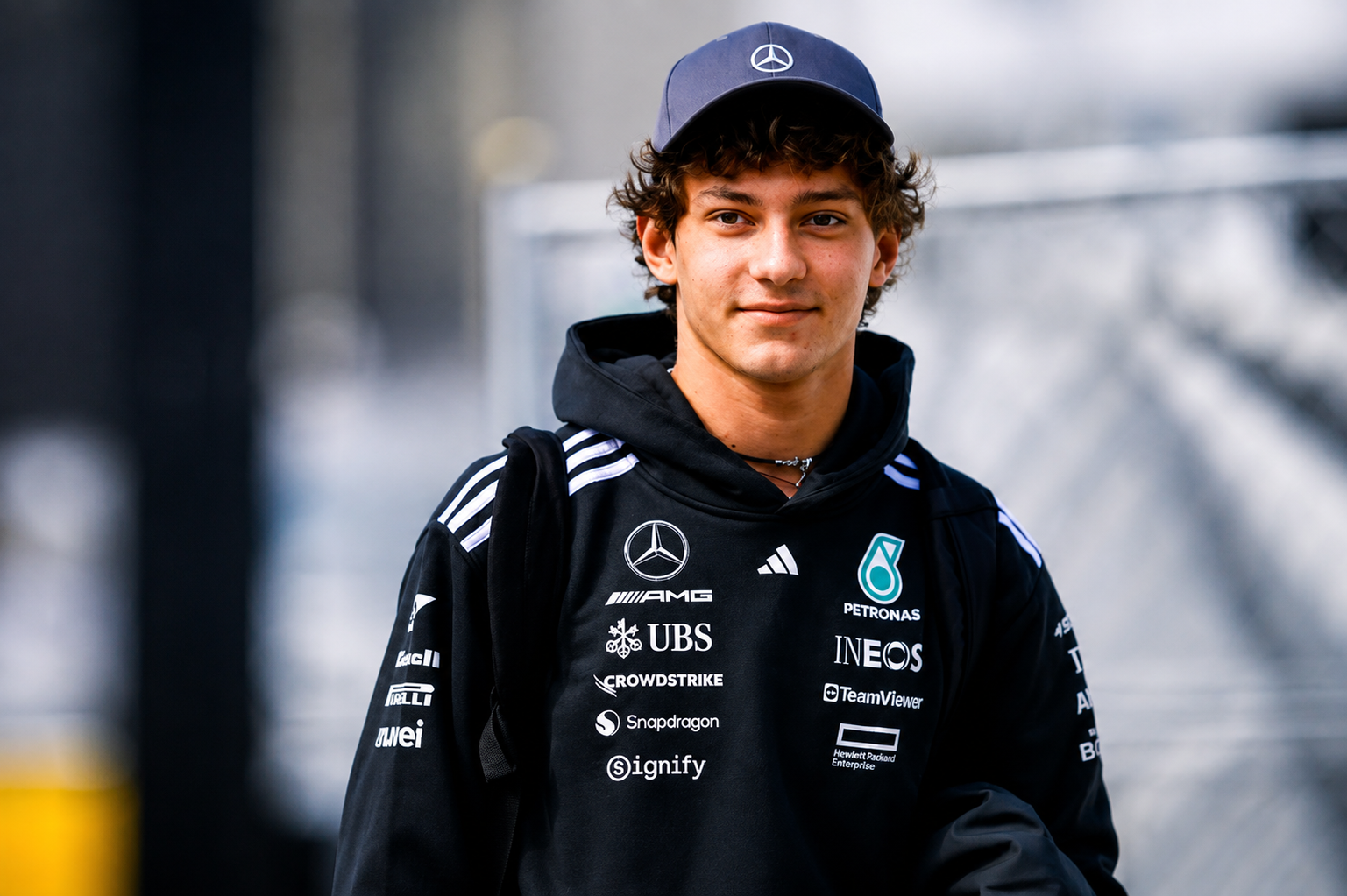 Kimi Antonelli wearing a Mercedes-AMG Petronas team hoodie and cap at a racetrack