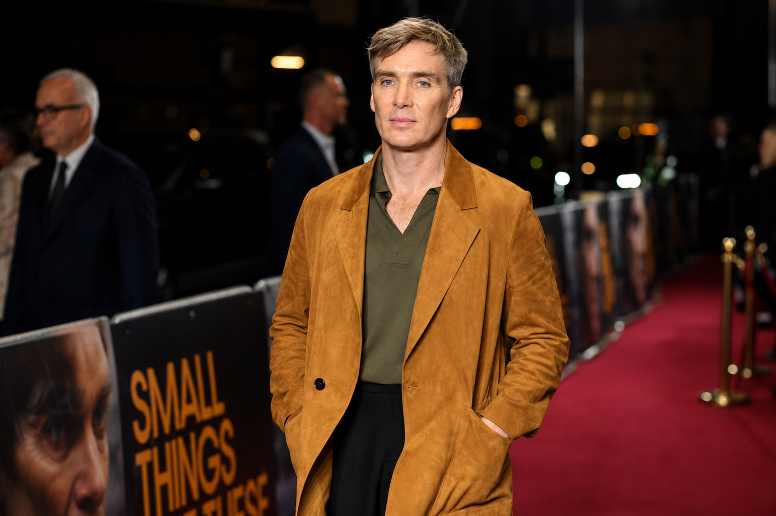 Cillian Murphy posing on the red carpet in a brown jacket