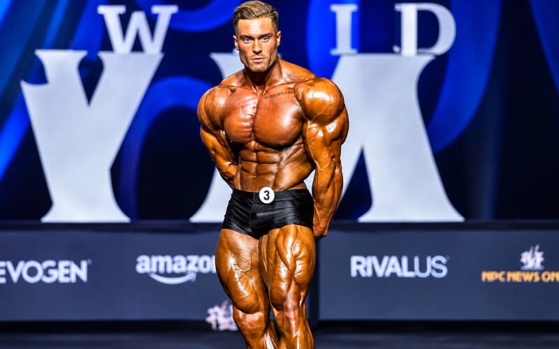 Chris Bumstead posing on stage during a professional bodybuilding competition