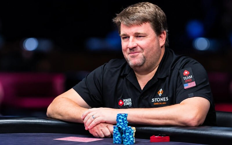 Chris Moneymaker sitting at a poker table with poker chips