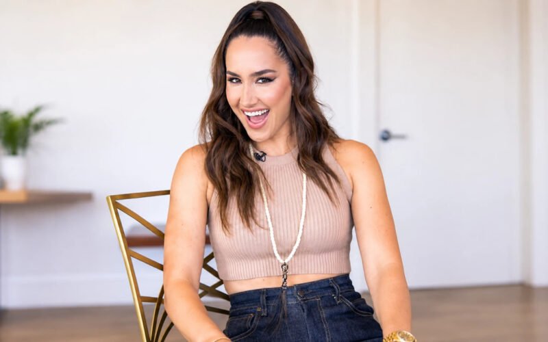 Codie Sanchez smiling while seated indoors in a casual outfit