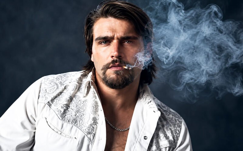 Gavin Adcock posing in a white patterned shirt with smoke in the background