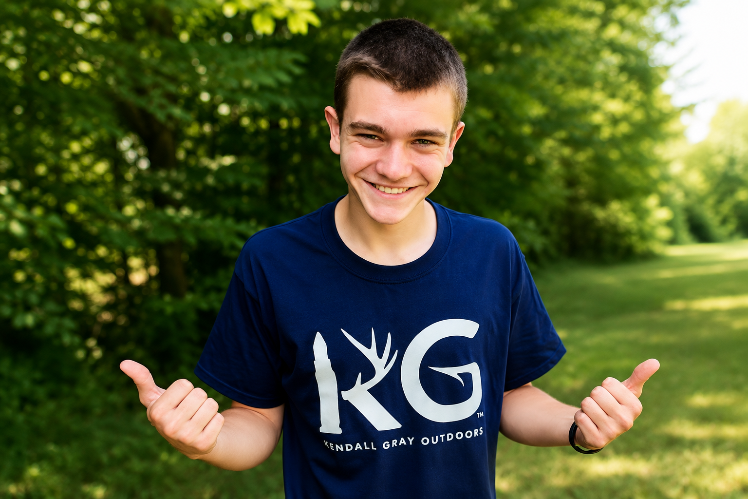Kendall Gray net worth 2026 – smiling outdoors in a navy Kendall Gray Outdoors T-shirt