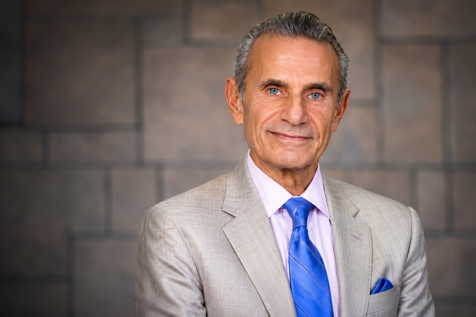 Charles Gamarekian net worth 2026 – smiling in a light gray suit and blue tie