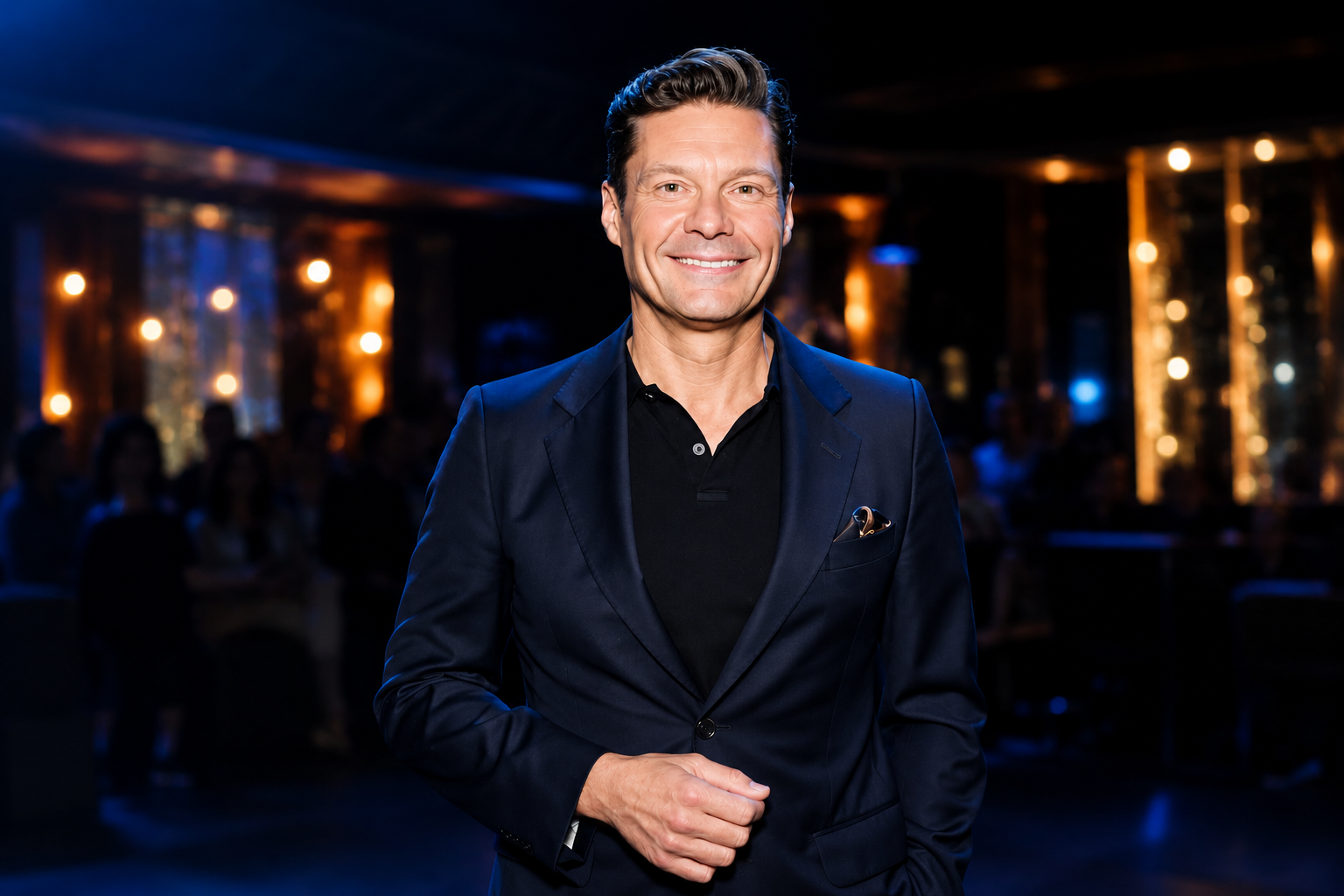 Ryan Seacrest net worth 2026 – smiling in a navy suit at an event