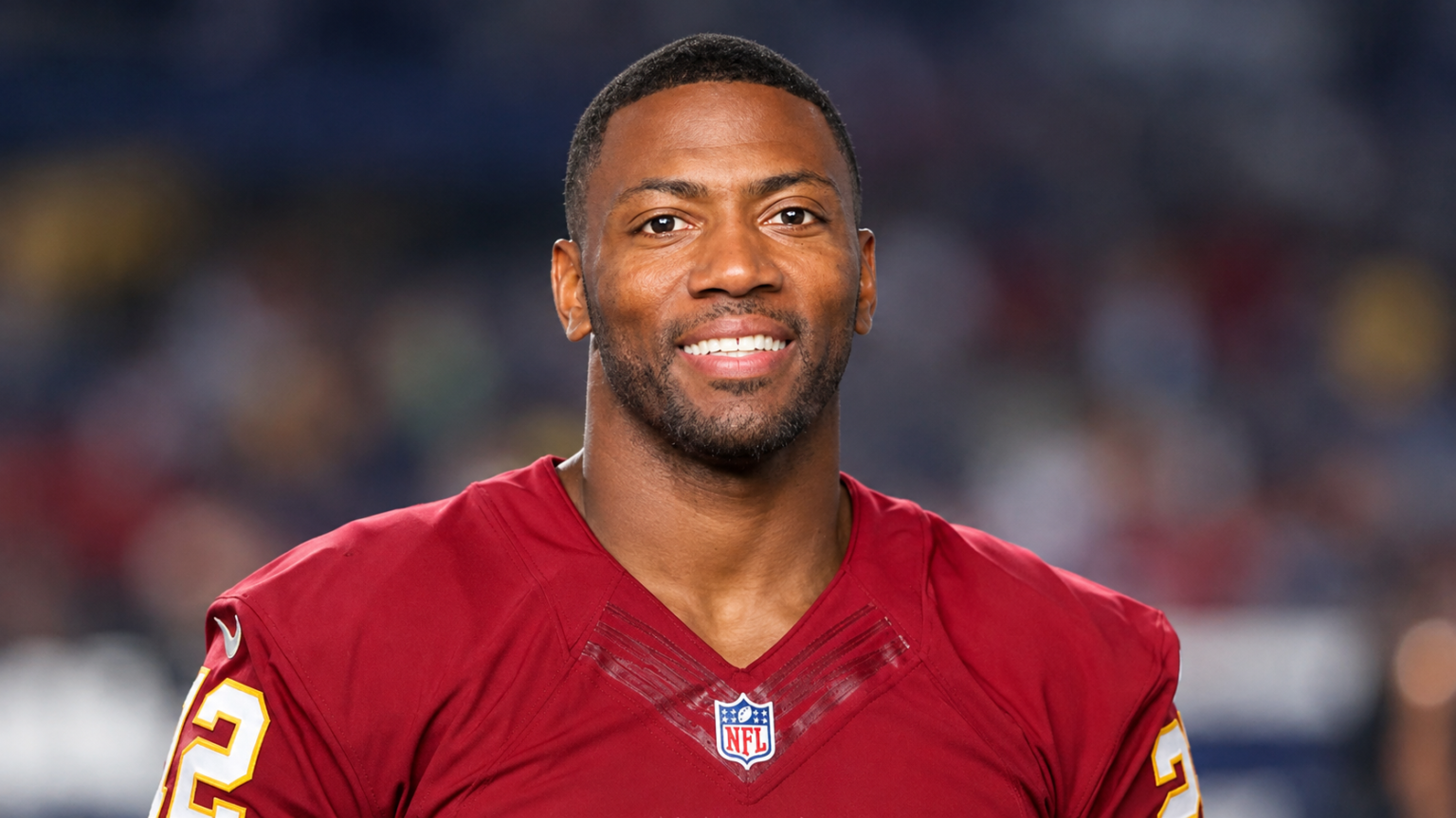 Ryan Clark net worth 2026 – wearing a football jersey and smiling at the camera