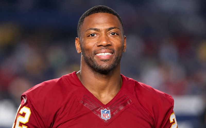 Ryan Clark net worth 2026 – wearing a football jersey and smiling at the camera
