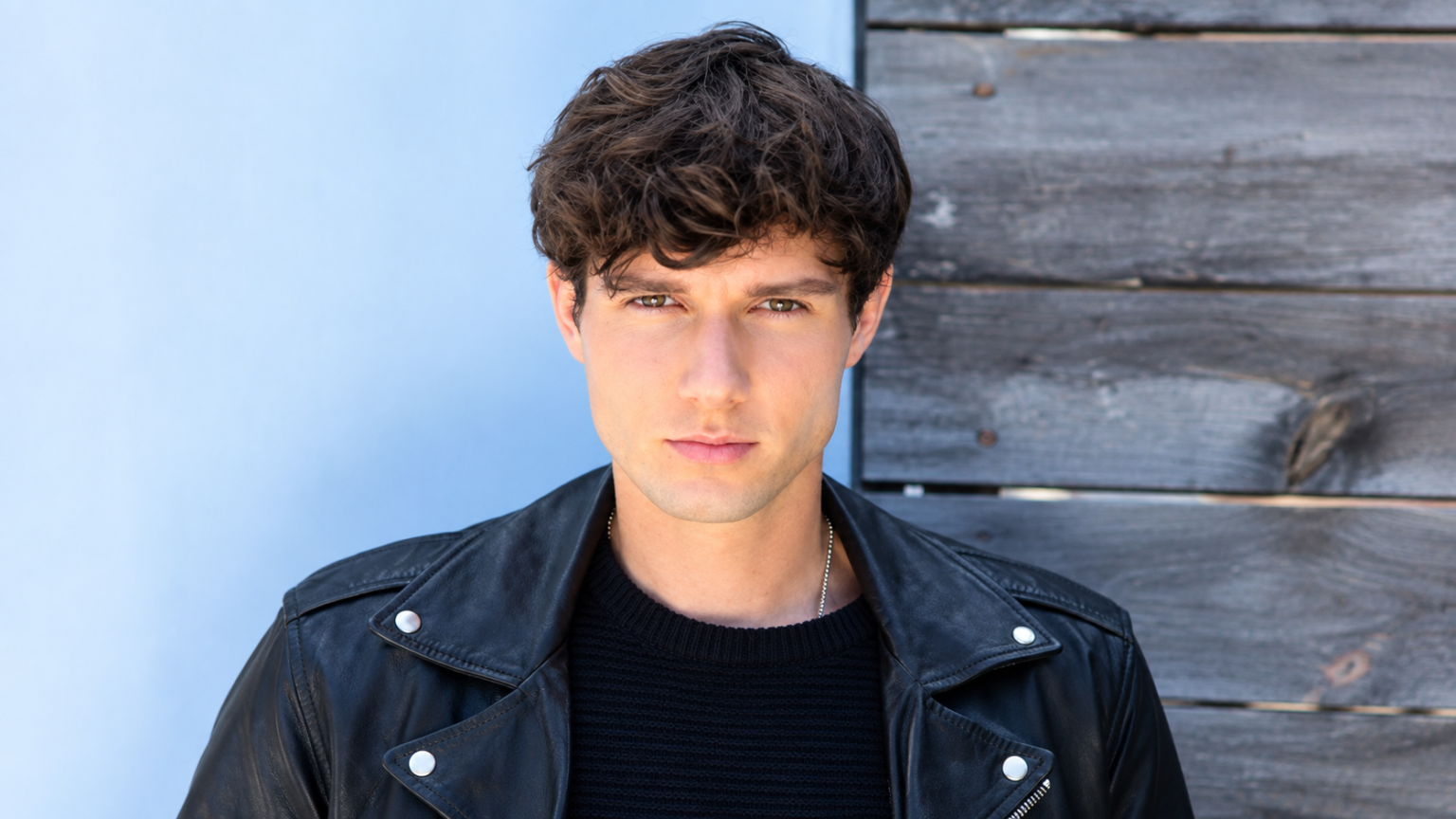 Zach Justice net worth 2026 – posing in a black leather jacket