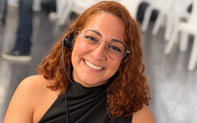 Lysaurie Ocasio net worth 2026 – smiling and wearing glasses at an indoor event