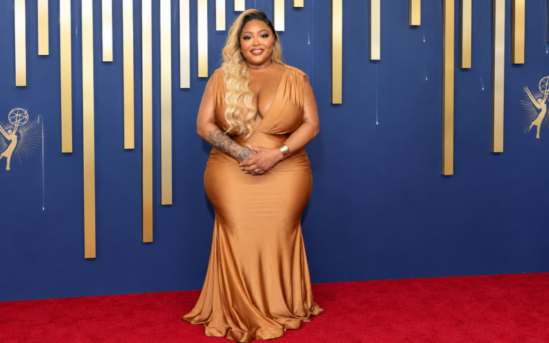 TS Madison posing on the red carpet in an elegant gold gown