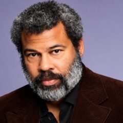Jordan Peele wearing a brown jacket in a professional portrait