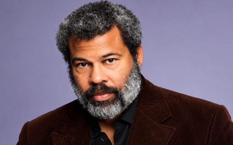 Jordan Peele wearing a brown jacket in a professional portrait