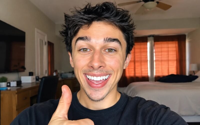 Tyler Vitelli smiling and giving a thumbs-up in a bedroom